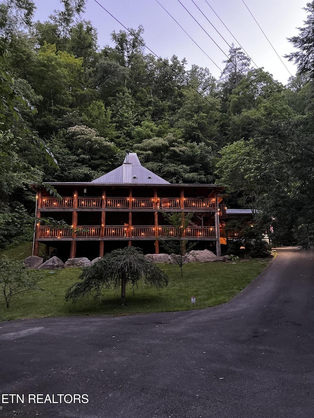 3014 N Clear Fork Rd, Sevierville, TN 37862 - view of front facade with a wooded view, a metal roof, and a wooden deck