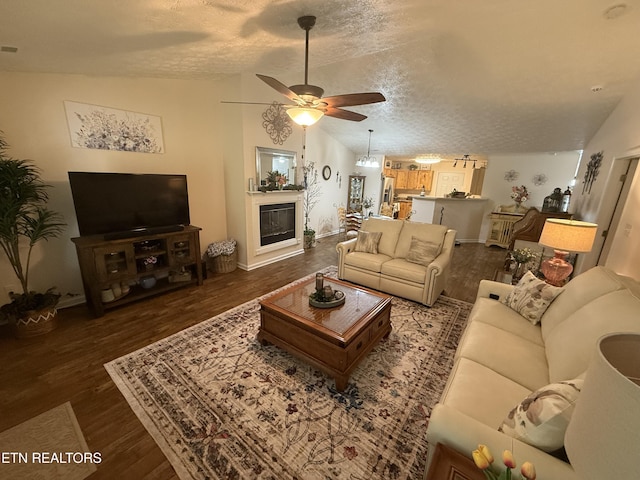7808 Stone Garden Way, Powell, TN 37849 - living area with vaulted ceiling, a textured ceiling, ceiling fan, wood finished floors, and a glass covered fireplace