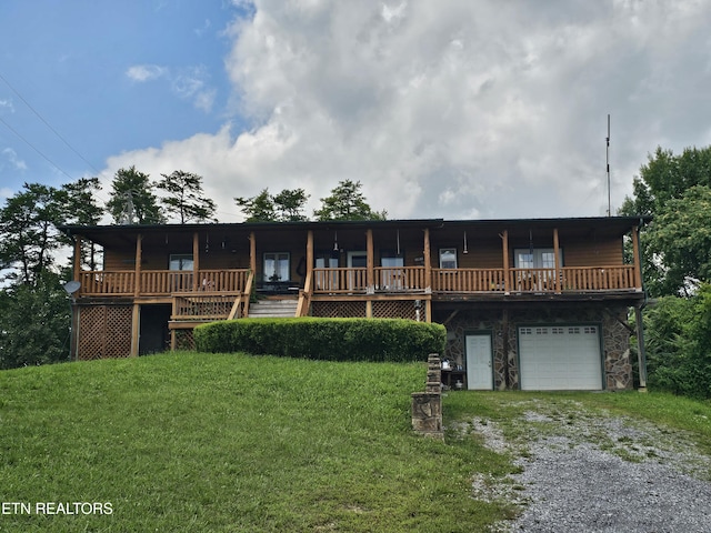 2440 Levee Way, Sevierville, TN 37876 - view of front of home featuring driveway, a garage, a front lawn, stone siding, and a deck