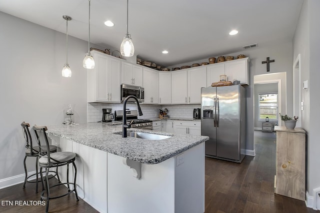 11944 Cordial Ln, Knoxville, TN 37932 - kitchen featuring stainless steel appliances, a peninsula, white cabinets, decorative backsplash, and light stone countertops