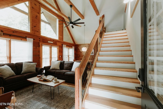 3653 Country Pines Way, Sevierville, TN 37876 - living room featuring a ceiling fan, stairs, high vaulted ceiling, wooden walls, and beamed ceiling
