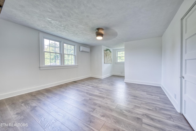 313 Edgewood Cir, Clinton, TN 37716 - empty room featuring a wall mounted air conditioner, wood finished floors, and a textured ceiling