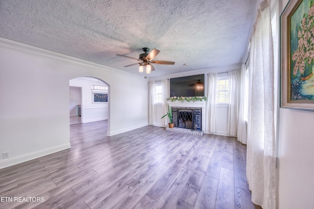 313 Edgewood Cir, Clinton, TN 37716 - unfurnished living room featuring ceiling fan, a textured ceiling, wood finished floors, ornamental molding, and arched walkways
