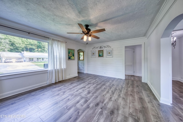 313 Edgewood Cir, Clinton, TN 37716 - unfurnished room with arched walkways, crown molding, a textured ceiling, wood finished floors, and a ceiling fan