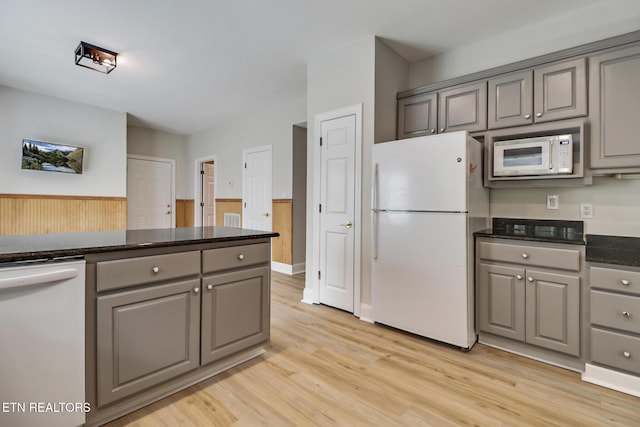 110 Lakecrest Ln, Oak Ridge, TN 37830 - kitchen featuring white appliances, gray cabinets, light wood-style flooring, wainscoting, and wood walls