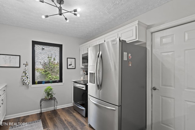 7217 Palermo Rd, Knoxville, TN 37918 - kitchen with appliances with stainless steel finishes, dark wood finished floors, a chandelier, a textured ceiling, and white cabinetry