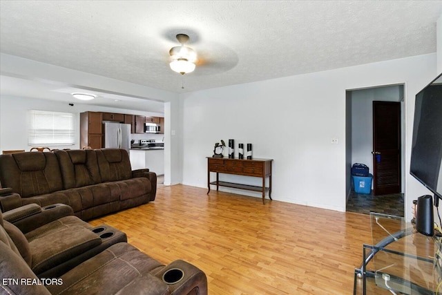 409 Meadow Ln, Middlesboro, KY 40965 - living room featuring light wood-type flooring, a ceiling fan, and a textured ceiling