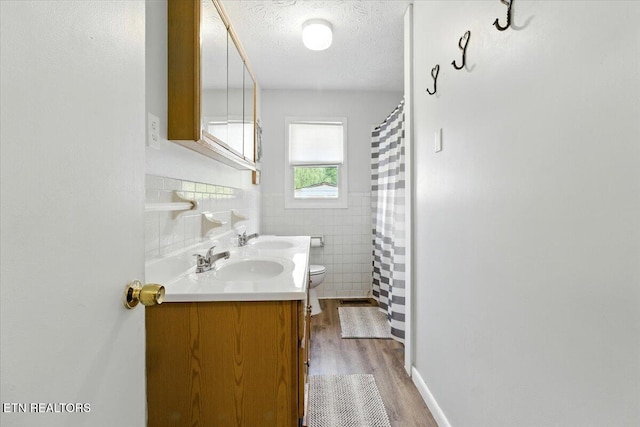 409 Meadow Ln, Middlesboro, KY 40965 - bathroom with wood finished floors, tile walls, double vanity, a textured ceiling, and curtained shower