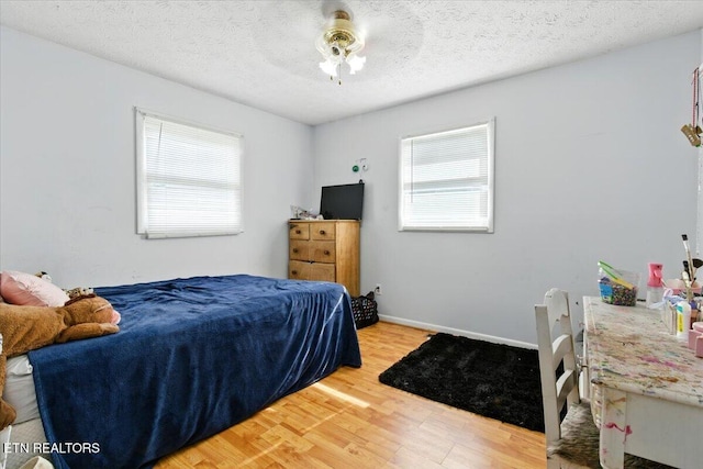 409 Meadow Ln, Middlesboro, KY 40965 - bedroom featuring multiple windows, light wood-style floors, a textured ceiling, and a ceiling fan