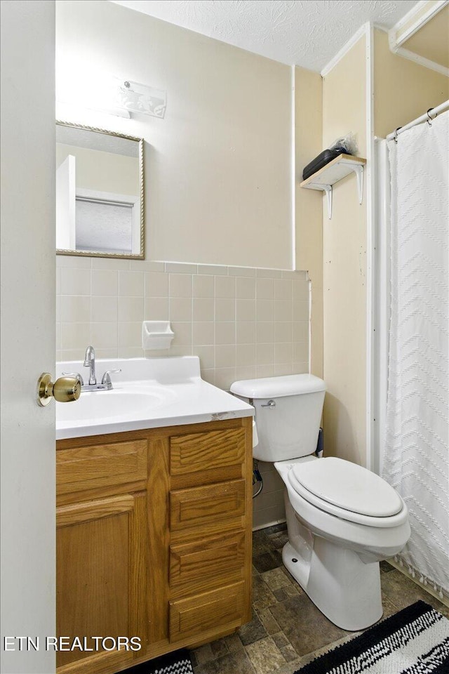 409 Meadow Ln, Middlesboro, KY 40965 - full bathroom featuring vanity, tile walls, stone finish flooring, a textured ceiling, and curtained shower