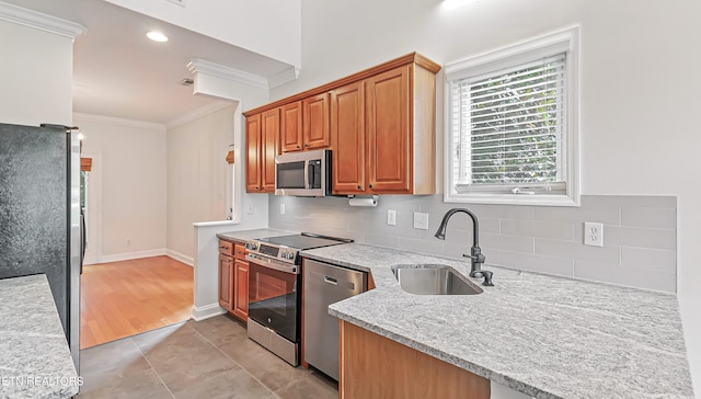 933 Gothic Manor Way, Knoxville, TN 37923 - kitchen with stainless steel appliances, ornamental molding, tasteful backsplash, light tile patterned floors, and light stone counters