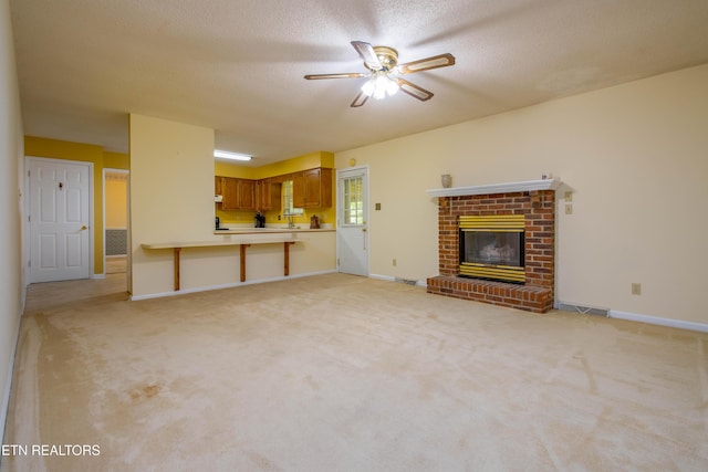 1705 Bobwhite Dr, Maryville, TN 37803 - unfurnished living room featuring a ceiling fan, light colored carpet, a fireplace, and a textured ceiling