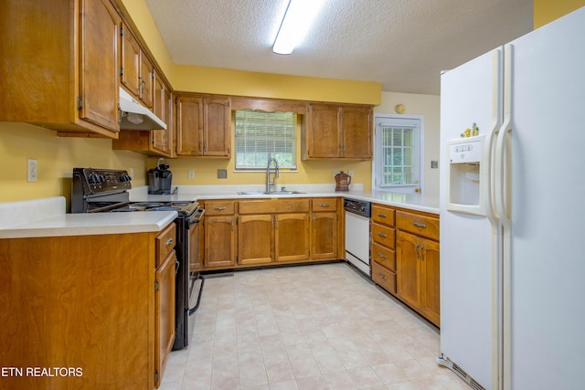 1705 Bobwhite Dr, Maryville, TN 37803 - kitchen featuring white appliances, under cabinet range hood, brown cabinetry, light countertops, and a textured ceiling