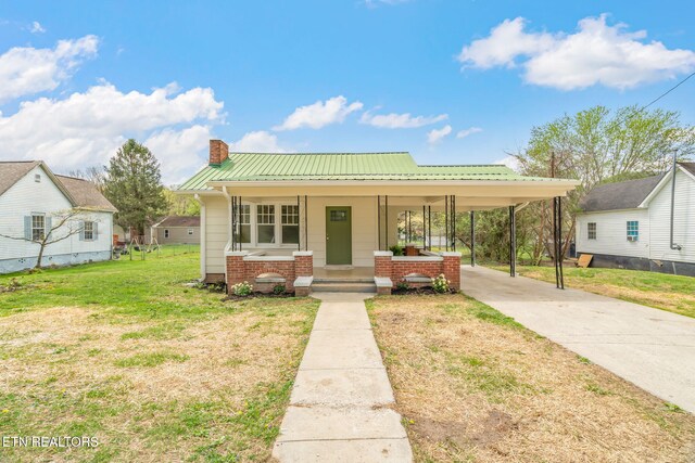 406 S Indiana Ave, Lafollette, TN 37766 - view of front of home with concrete driveway, a chimney, a carport, a front yard, and a porch