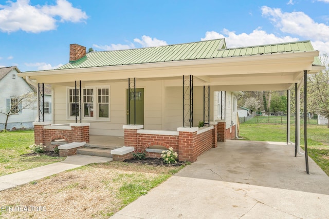 406 S Indiana Ave, Lafollette, TN 37766 - view of front of home featuring a chimney, covered porch, concrete driveway, an attached carport, and a metal roof