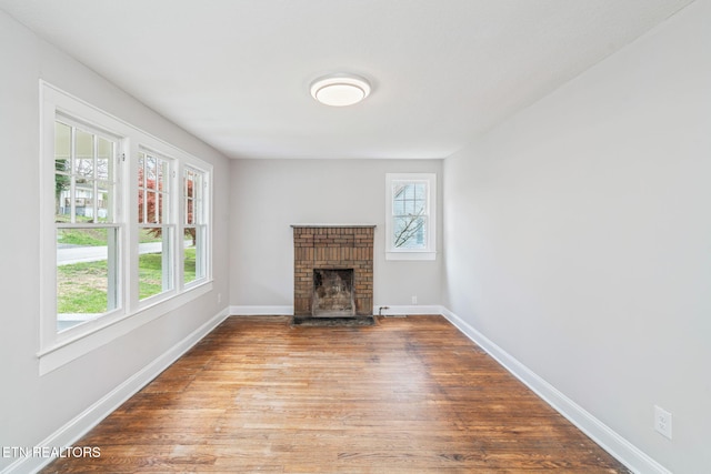 406 S Indiana Ave, Lafollette, TN 37766 - unfurnished living room with plenty of natural light, wood finished floors, and a brick fireplace