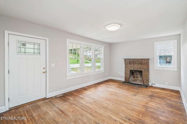 406 S Indiana Ave, Lafollette, TN 37766 - unfurnished living room with plenty of natural light, wood finished floors, and a fireplace