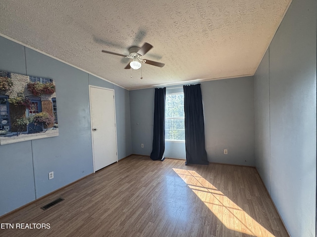 167 Marina Ln, Lafollette, TN 37766 - spare room with wood finished floors, ceiling fan, vaulted ceiling, a textured ceiling, and crown molding