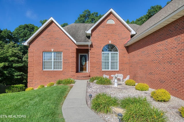 2150 Hirst Cir, Lenoir City, TN 37771 - view of front facade featuring brick siding, roof with shingles, and a front lawn