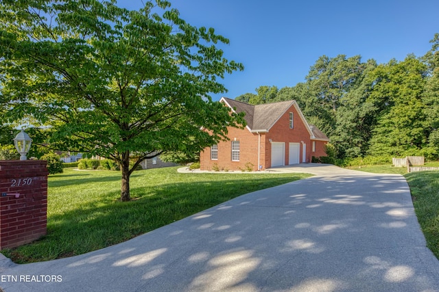 2150 Hirst Cir, Lenoir City, TN 37771 - view of property exterior featuring brick siding, driveway, a yard, and an attached garage