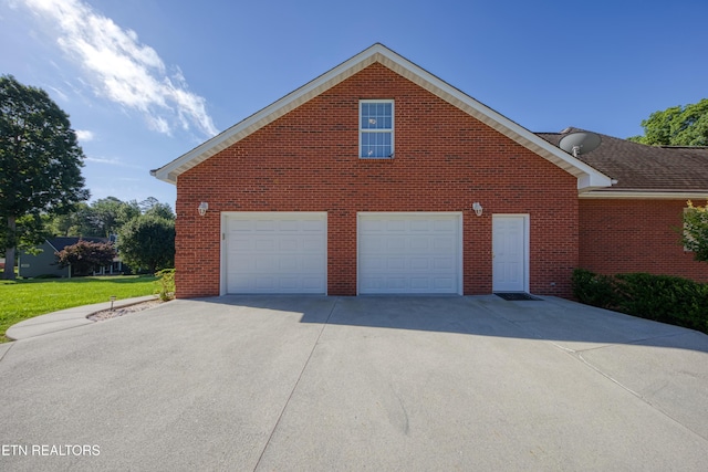 2150 Hirst Cir, Lenoir City, TN 37771 - view of home's exterior featuring a garage, brick siding, and concrete driveway