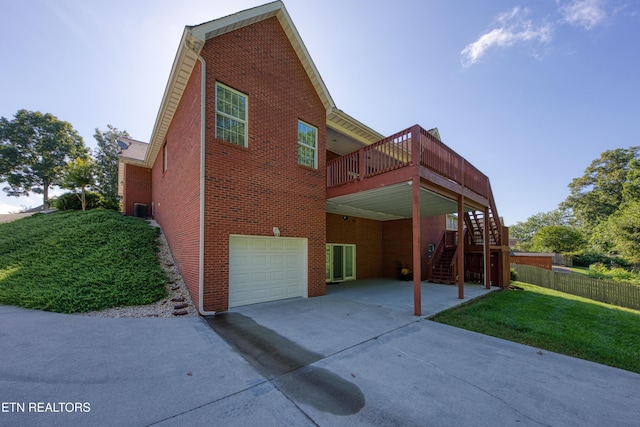 2150 Hirst Cir, Lenoir City, TN 37771 - rear view of house featuring brick siding, concrete driveway, an attached garage, stairway, and a wooden deck