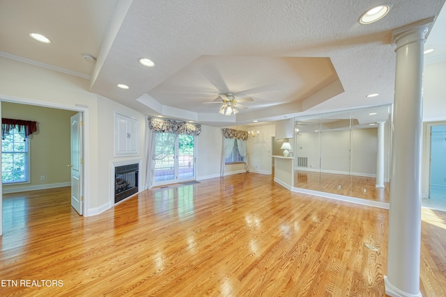 2150 Hirst Cir, Lenoir City, TN 37771 - unfurnished living room with decorative columns, a raised ceiling, ceiling fan, light wood-type flooring, and a fireplace