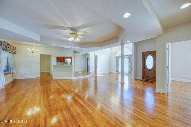 2150 Hirst Cir, Lenoir City, TN 37771 - unfurnished living room with a chandelier, decorative columns, ceiling fan, a textured ceiling, and light wood-type flooring
