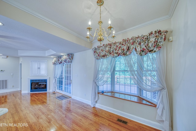 2150 Hirst Cir, Lenoir City, TN 37771 - unfurnished dining area with a chandelier, wood finished floors, a fireplace, and crown molding