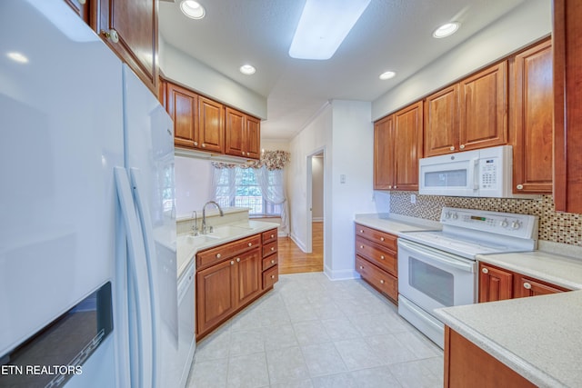 2150 Hirst Cir, Lenoir City, TN 37771 - kitchen featuring white appliances, decorative backsplash, brown cabinetry, light countertops, and recessed lighting