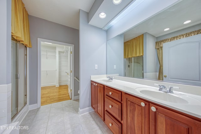 2150 Hirst Cir, Lenoir City, TN 37771 - bathroom with double vanity, a walk in closet, tile patterned floors, a stall shower, and recessed lighting