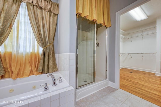 2150 Hirst Cir, Lenoir City, TN 37771 - full bath featuring a stall shower, a jetted tub, tile patterned floors, and a spacious closet