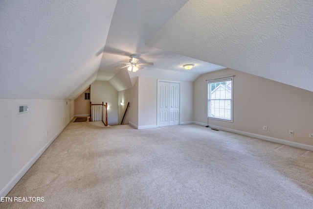 2150 Hirst Cir, Lenoir City, TN 37771 - bonus room featuring a textured ceiling, vaulted ceiling, light carpet, and a ceiling fan
