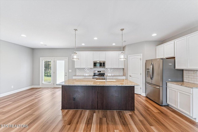 8630 Yellow Aster Rd, Knoxville, TN 37931 - kitchen featuring stainless steel appliances, decorative backsplash, light wood-style flooring, white cabinetry, and a center island with sink