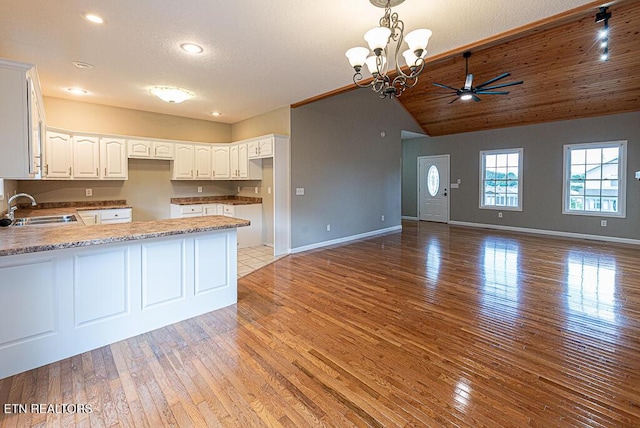 200 W Park Cir, Decatur, TN 37322 - kitchen featuring a peninsula, a ceiling fan, light wood-style flooring, white cabinets, and vaulted ceiling
