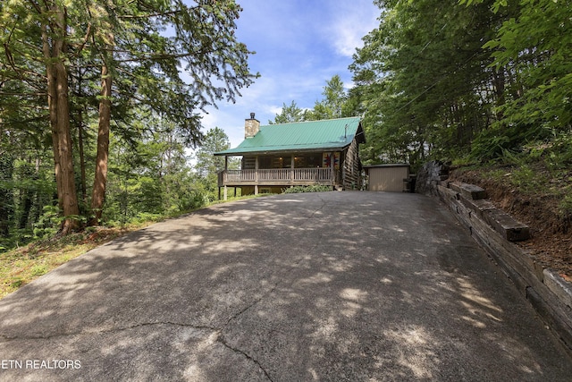 2526 N School House Gap Rd, Sevierville, TN 37876 - cabin featuring a chimney, covered porch, a metal roof, and driveway