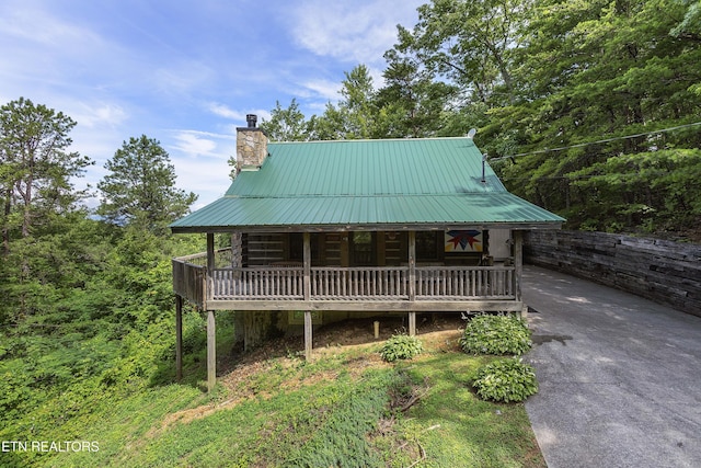2526 N School House Gap Rd, Sevierville, TN 37876 - view of front facade with a chimney, concrete driveway, a metal roof, and log exterior