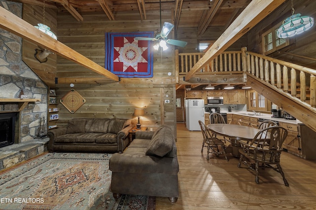 2526 N School House Gap Rd, Sevierville, TN 37876 - living area with a towering ceiling, wood walls, a wood ceiling with exposed beams, light wood-type flooring, and stairway