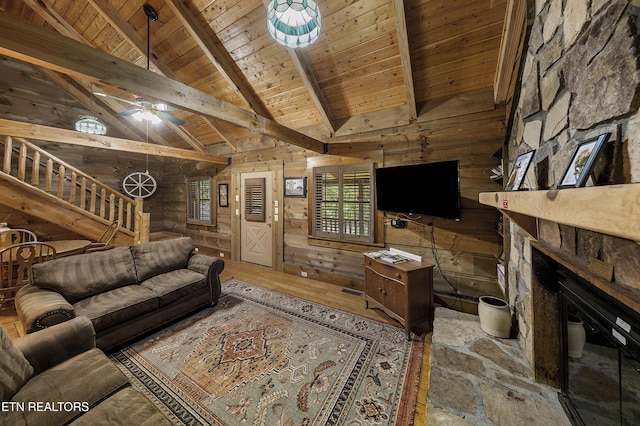 2526 N School House Gap Rd, Sevierville, TN 37876 - living area with a wood ceiling with exposed beams, wood walls, stairs, a fireplace, and a ceiling fan
