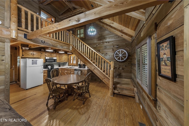 2526 N School House Gap Rd, Sevierville, TN 37876 - dining space with wood walls, light wood finished floors, stairs, high vaulted ceiling, and a wooden ceiling with exposed beams