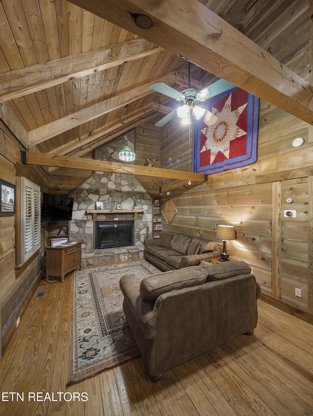 2526 N School House Gap Rd, Sevierville, TN 37876 - living area with wooden ceiling, wood-type flooring, wood walls, ceiling fan, and a stone fireplace