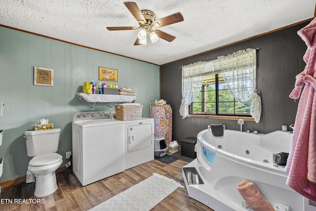4720 Laws Rd, Del Rio, TN 37727 - bathroom with independent washer and dryer, a tub with jets, ceiling fan, wood finished floors, and ornamental molding