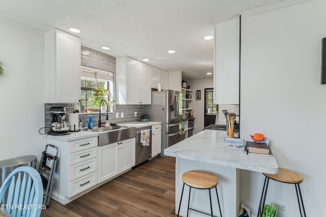 124 Pheasant Rd, Clinton, TN 37716 - kitchen featuring stainless steel appliances, a kitchen breakfast bar, tasteful backsplash, white cabinetry, and healthy amount of natural light