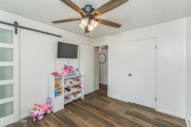 124 Pheasant Rd, Clinton, TN 37716 - recreation room featuring a ceiling fan, dark wood-type flooring, a barn door, and a textured ceiling
