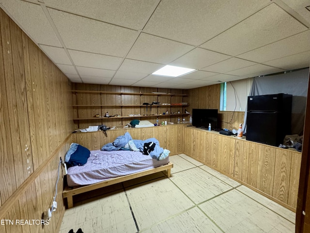 103 Albany Rd, Oak Ridge, TN 37830 - bedroom featuring freestanding refrigerator, wooden walls, a paneled ceiling, and tile patterned floors