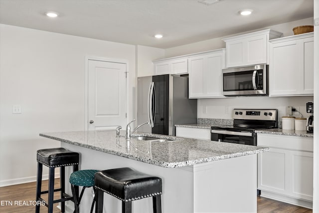 213 Newman Cir, Jefferson City, TN 37760 - kitchen with appliances with stainless steel finishes, white cabinets, an island with sink, a breakfast bar area, and recessed lighting