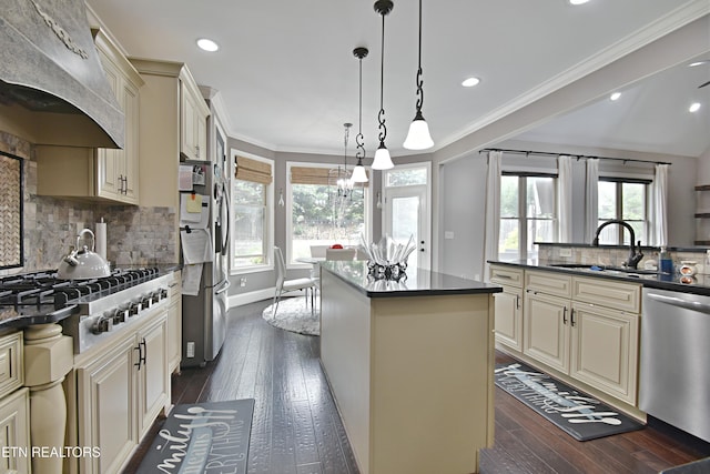 11957 Lakehurst Ln, Knoxville, TN 37934 - kitchen featuring appliances with stainless steel finishes, cream cabinetry, custom range hood, dark countertops, and a center island