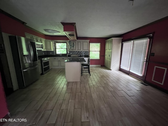 435 Simms Fork Rd, Arjay, KY 40902 - kitchen with appliances with stainless steel finishes, a breakfast bar area, light wood-style flooring, dark countertops, and a center island