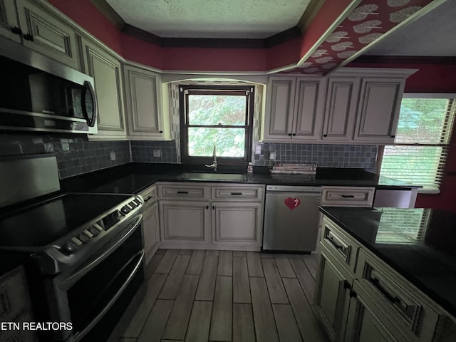 435 Simms Fork Rd, Arjay, KY 40902 - kitchen with stainless steel appliances, dark countertops, backsplash, a textured ceiling, and light wood-style floors