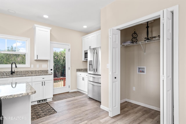 177 Hidden River Ave, Sparta, TN 38583 - kitchen with appliances with stainless steel finishes, light wood-style floors, white cabinets, healthy amount of natural light, and recessed lighting